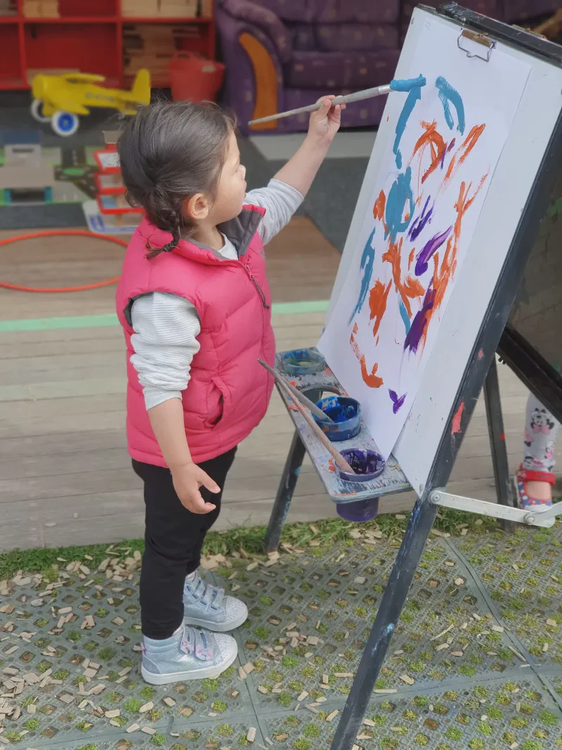 Child painting at an easel